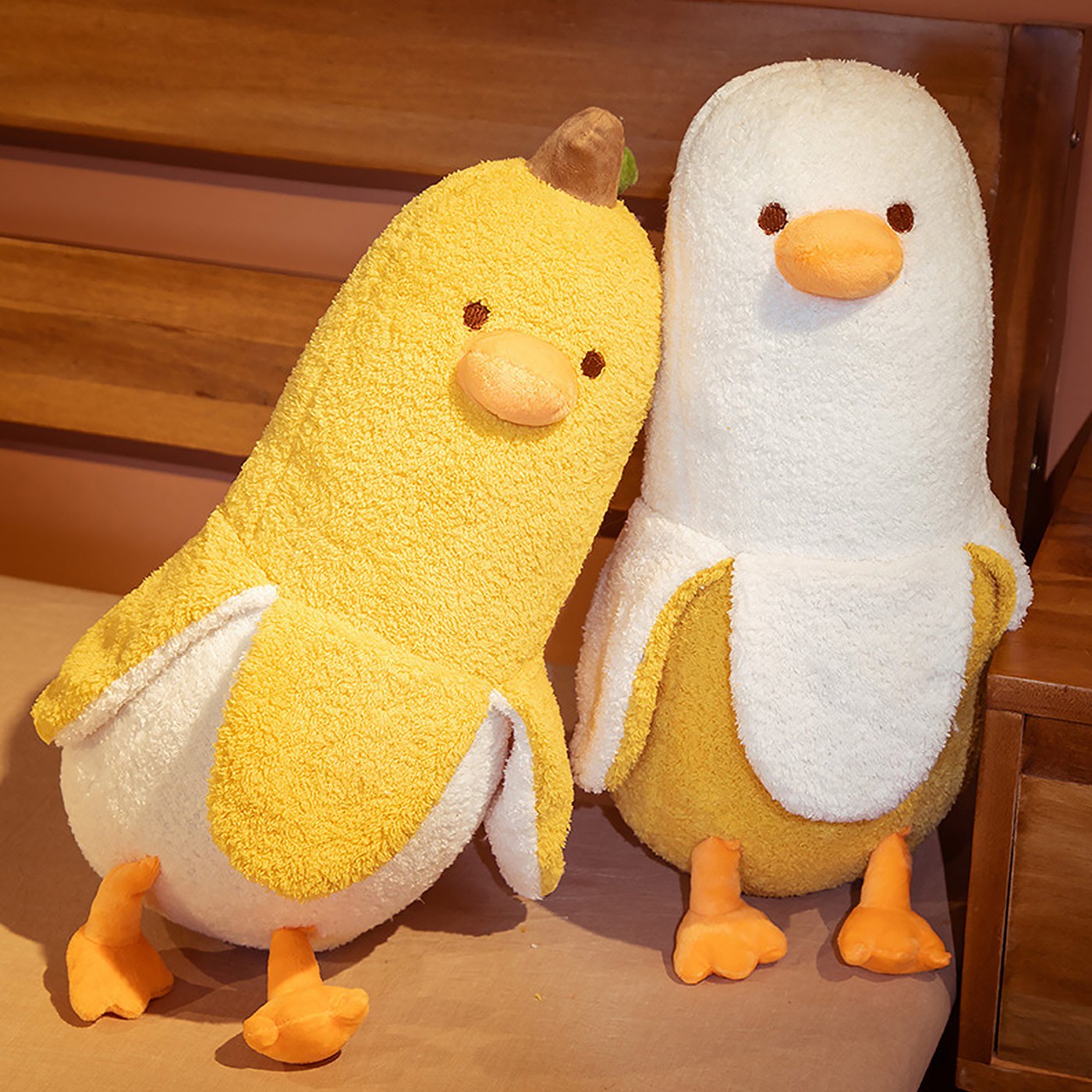 A yellow and a white PEACH CAT banana duck plush sitting together
